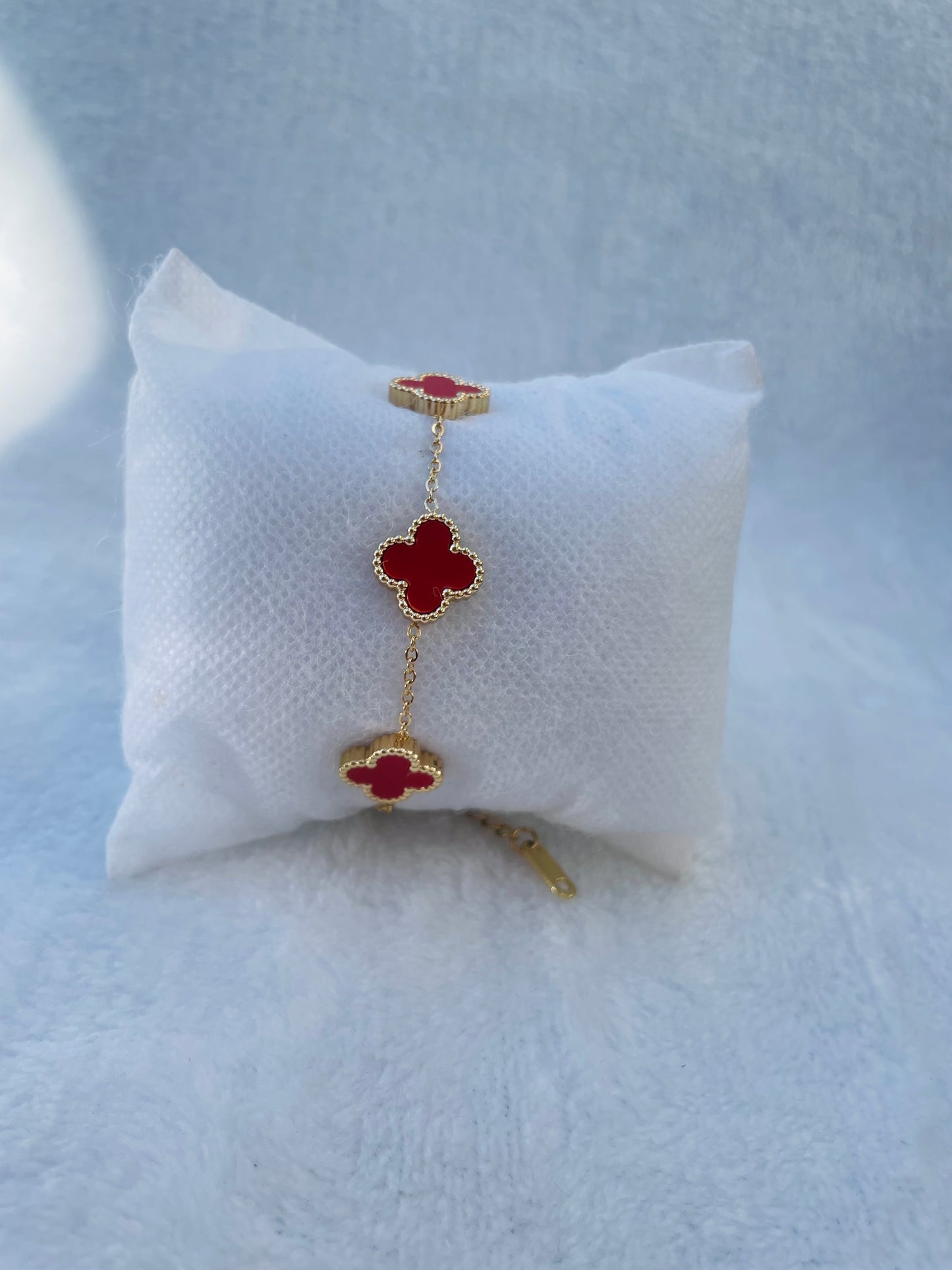 Pulsera trébol dorada con detalles rojos